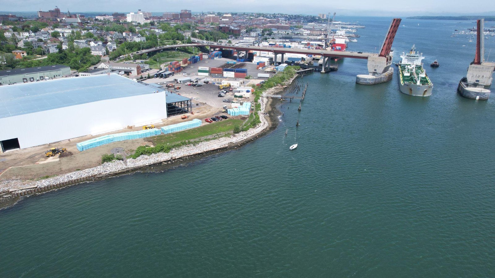 This photo shows an aerial view of a port where ships are docked.