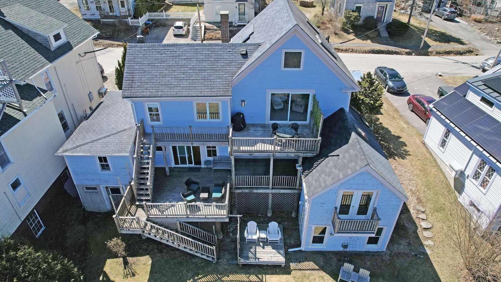 Aerial drone view of a multi-unit residential property showing rooftops, decks, and surrounding structures.