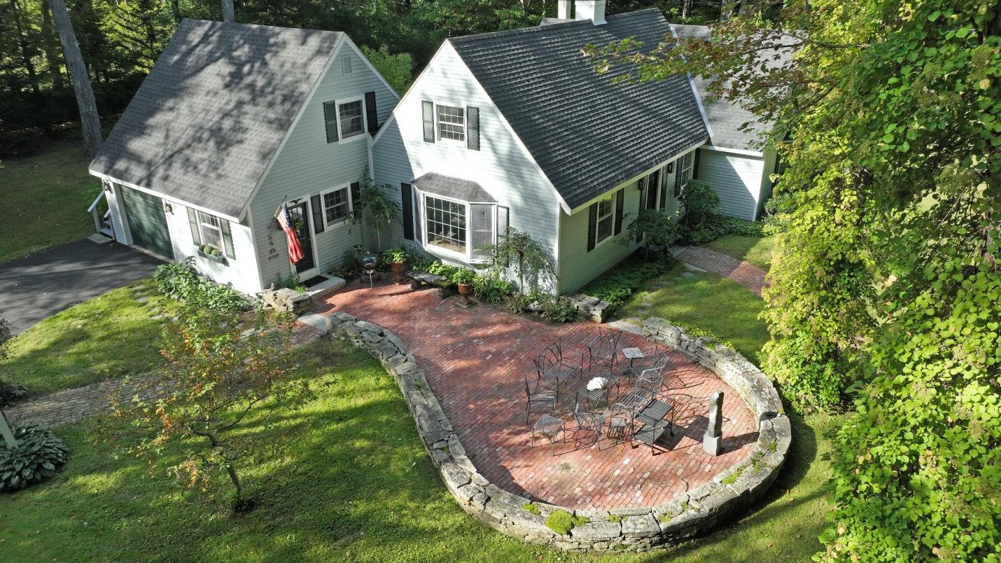 drone shot of the backyard of a house surrounded by greenery