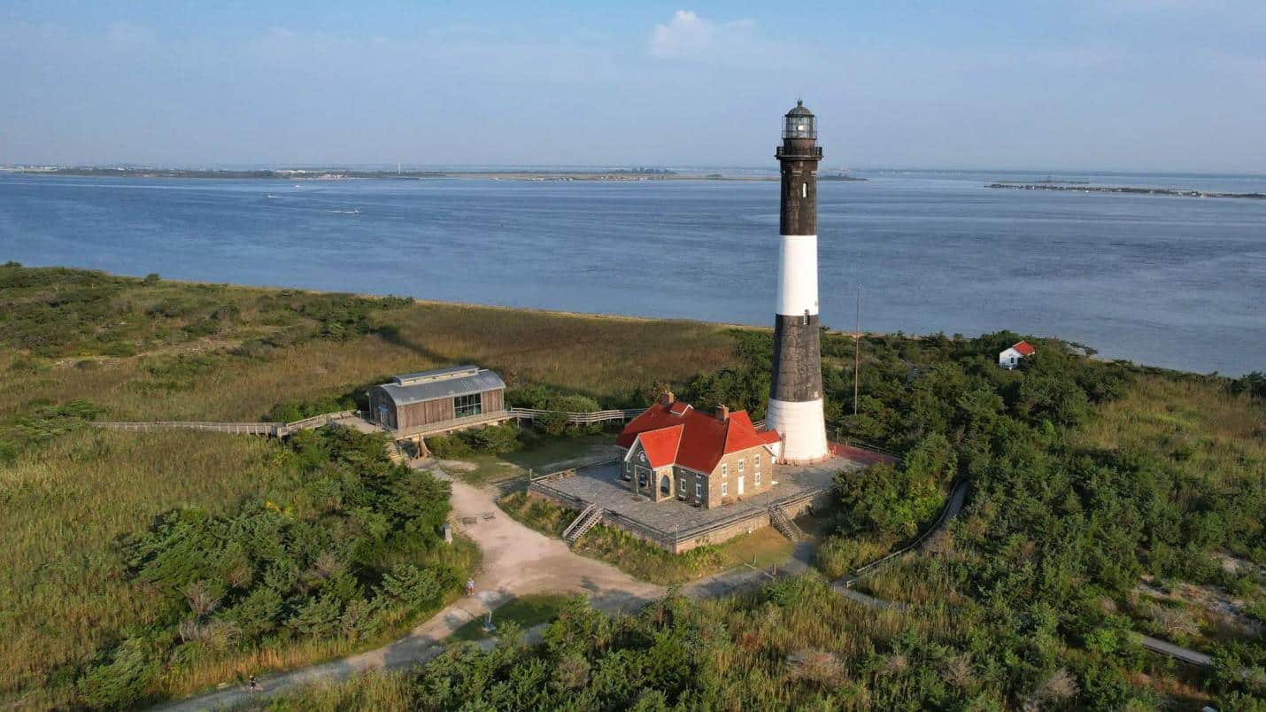 a lighthouse surrounded by green fields