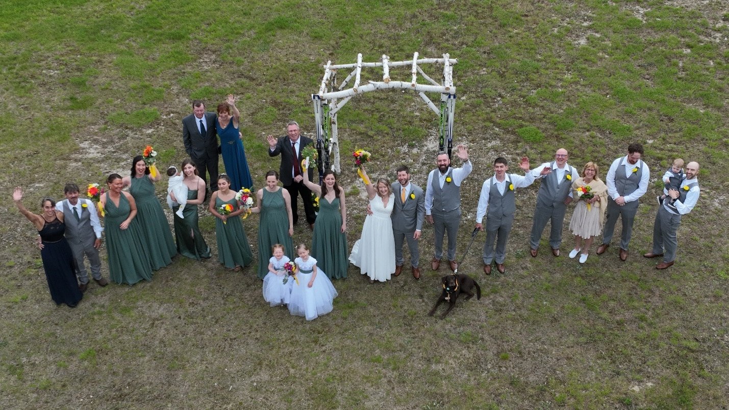 Aerial drone photograph of a wedding party gathered outdoors at Pleasant Mountain, ME